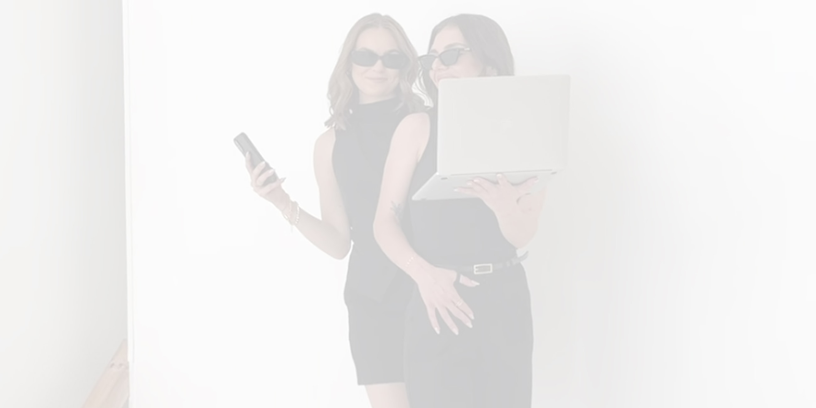 Two women in black outfits with technology.