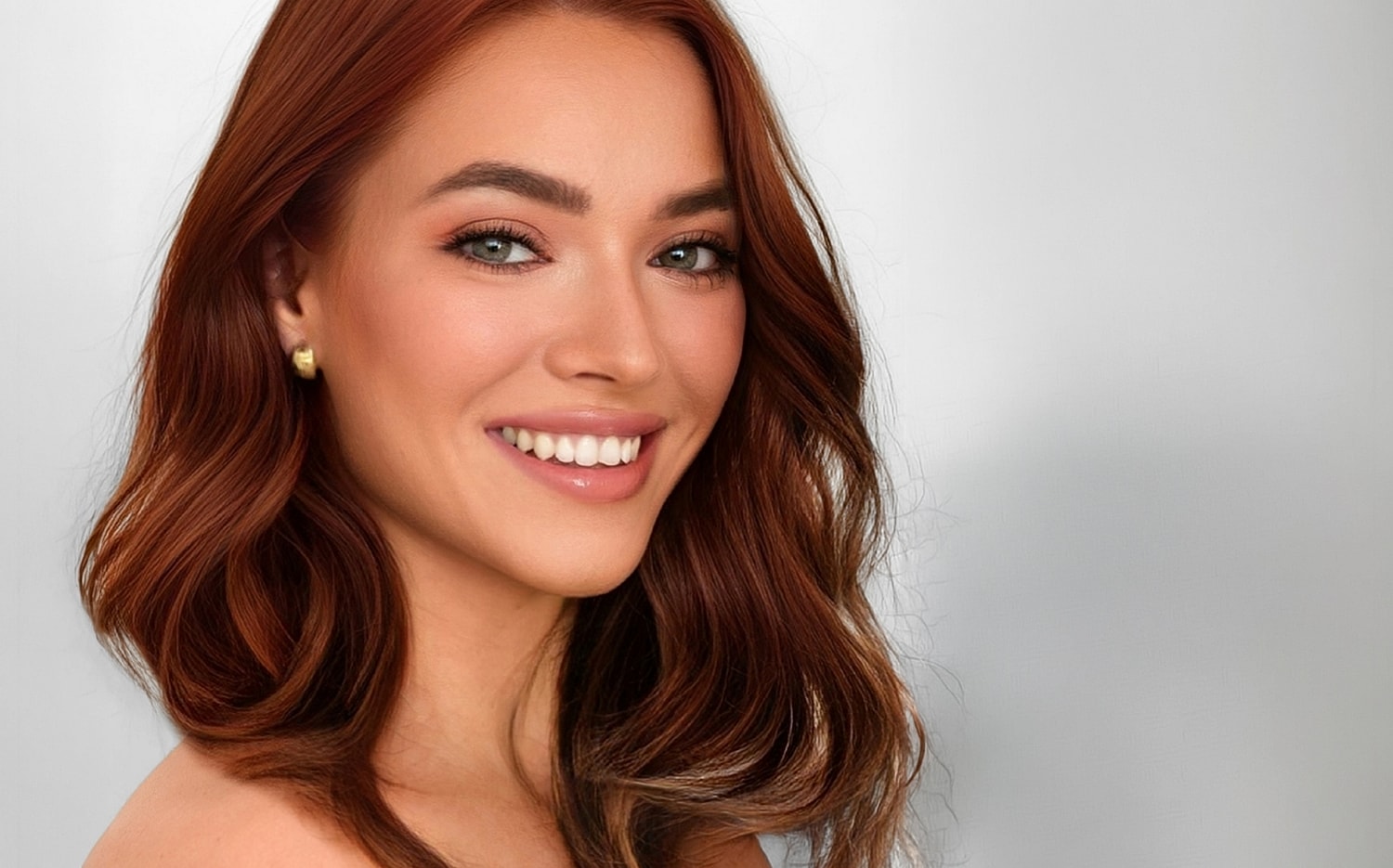 Smiling woman with long, wavy brown hair.