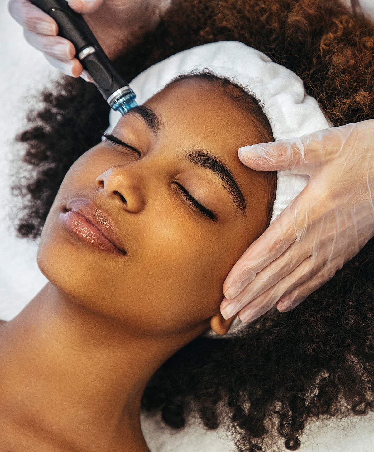 Facial treatment being applied to a relaxed woman.