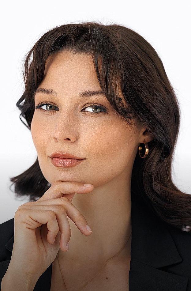 Confident woman with thoughtful expression, wearing gold earrings.
