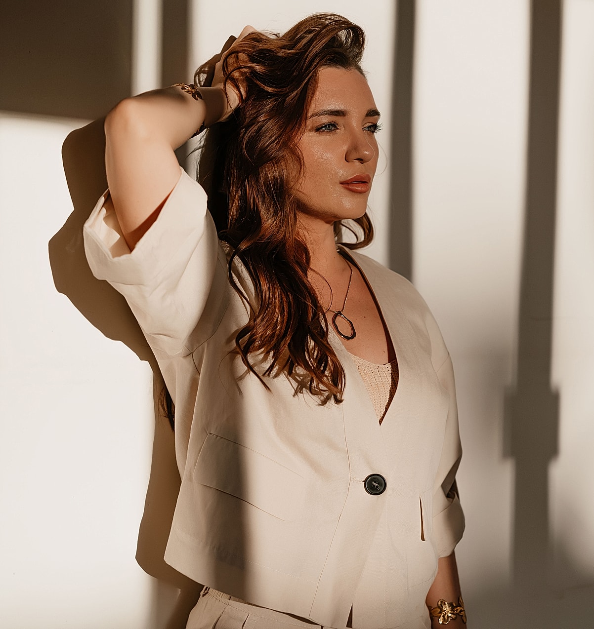 Woman in stylish outfit illuminated by natural light.