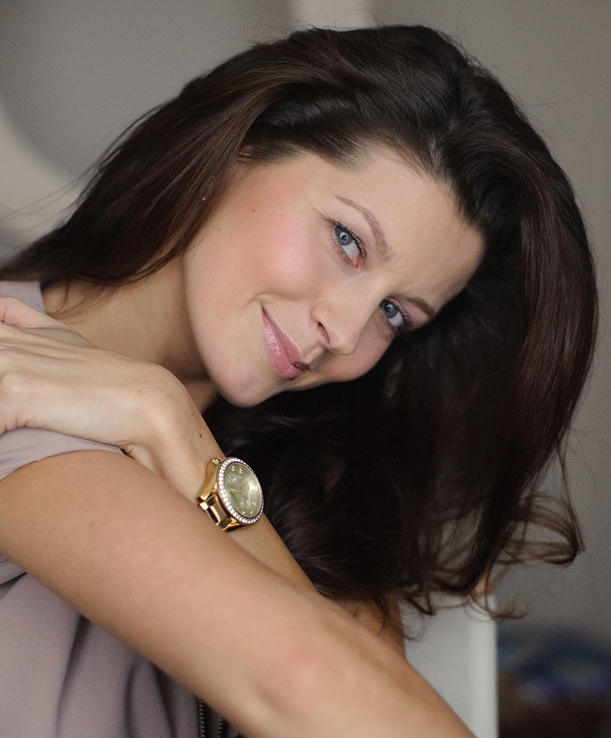 Smiling woman with long hair and watch.