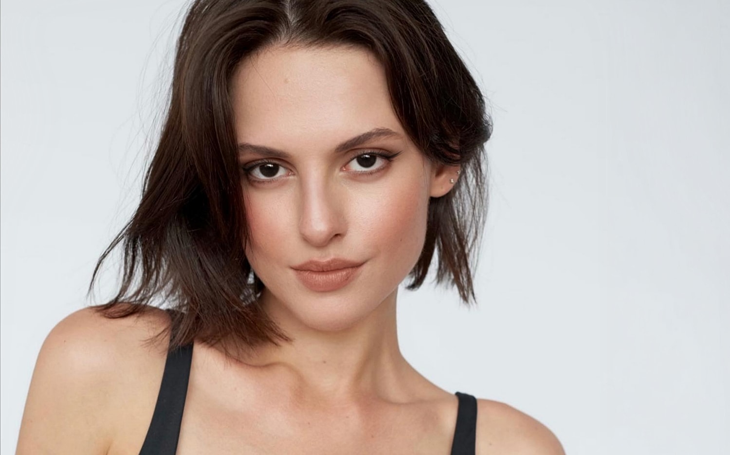Woman with short hair and natural makeup.
